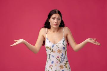 Beautiful young girl spreads her arms on the pink background