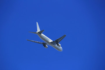 White jet airliner flying in the clear blue sky