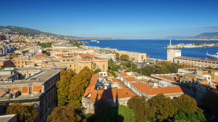 Fototapeta premium Panoramic top view of the local buildings with the trees, mountains and the sky in the beautiful city of Messina, Sicily, Italy