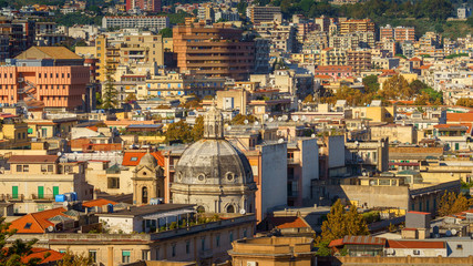 Fototapeta premium Panoramic top view of the local buildings with the trees, mountains and the sky in the beautiful city of Messina, Sicily, Italy