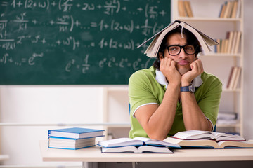 Handsome student in front of chalkboard with formulas 