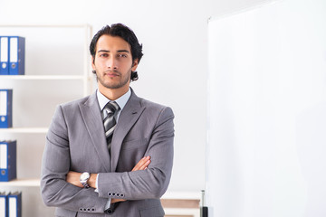 Young handsome businessman in front of whiteboard 