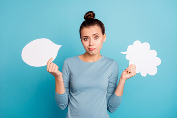 Portrait of her she nice attractive lovely doubtful girl holding in hands two boards copy empty blank space isolated over bright vivid shine turquoise background