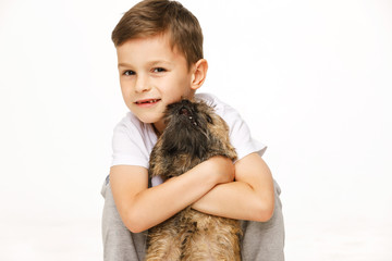 little boy is hugging the dog studio shot 