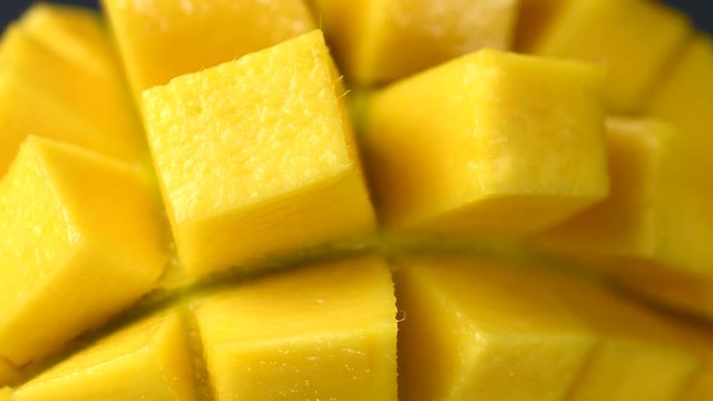 Rotation close-up of rip mango slice cubes cut in 4K resolution