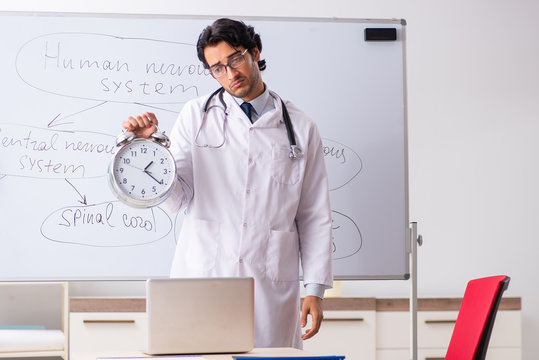 Young male doctor neurologist in front of whiteboard 