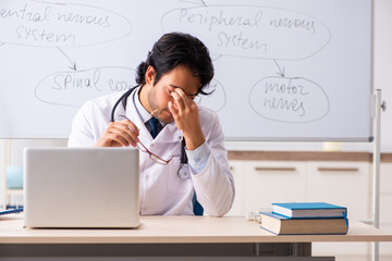 Young male doctor neurologist in front of whiteboard 