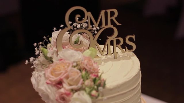 Close up shot of a wedding cake with Mr & MRS topper