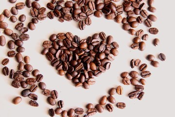 scattered on the table roasted coffee beans in the shape of a heart, selective focus. coffee beans after roasting, close-up