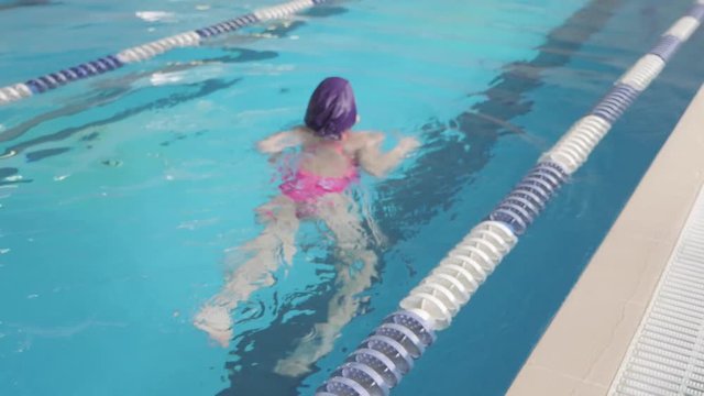 Girl child in swimming pool. Smiling child leads a healthy lifestyle and keen on sports.