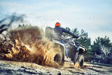 Teen riding ATV in sand dunes making a turn in the sand © 6okean