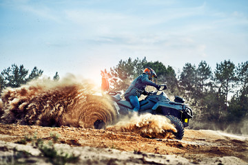 Teen riding ATV in sand dunes making a turn in the sand © 6okean
