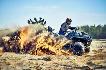 Teen riding ATV in sand dunes making a turn in the sand © 6okean