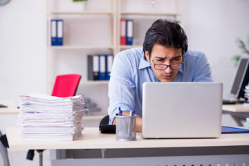 Young male businessman employee unhappy with excessive work  