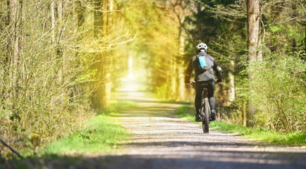 Fototapeta na wymiar Mann fährt auf seinem Fahrrad durch den Wald