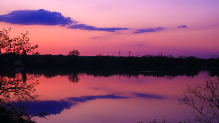 beautiful landscape over the water with symmetry of clouds in colorful sky at sunset