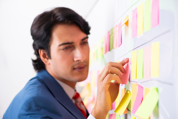 Young handsome employee with many conflicting priorities 