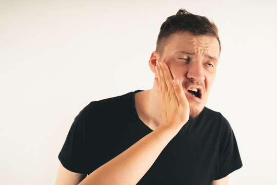 Emotional male getting slapped in face while shouting with closed eyes in fear on white background