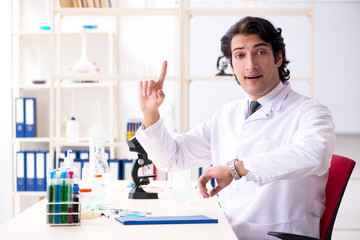 Young handsome chemist working in the lab 