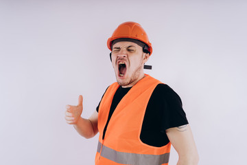 Man in working uniform on white background Portrait of young male in bright orange protective hardhat and vest looking at camera on white background