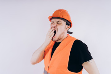 Man in working uniform on white background Portrait of young male in bright orange protective hardhat and vest looking at camera on white background