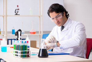 Young handsome chemist working in the lab 