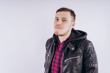 Obraz premium Man in trendy jacket on white background Portrait of young male in leather jacket zipping up and smiling at camera on white background