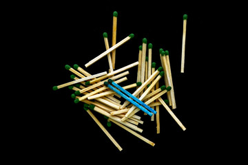 homosexuality concept: 2 blue matches opposite a pile of ordinary matches, black background