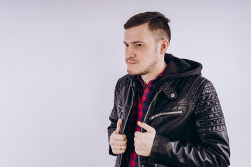 Man in trendy jacket on white background Portrait of young male in leather jacket zipping up and smiling at camera on white background