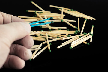 homosexuality concept: 2 blue matches opposite a pile of ordinary matches, black background