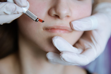 Permanent makeup for lips. Young woman getting permanent in a beauty studio