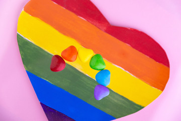 struggle for happiness and equality of sexual minorities: 6 multi-colored candy with the rainbow color of the LGBT flag, short focus, pink background