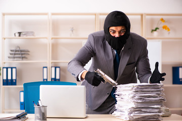 Male gangster stealing information from the office 