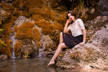 Beautiful girl posing in river, fairy fast forest in autumn.  Beauty, fashion. Spa, healthcare. Tropical vacation. Natural pool.