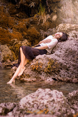Beautiful girl posing in river, fairy fast forest in autumn.  Beauty, fashion. Spa, healthcare. Tropical vacation. Natural pool.
