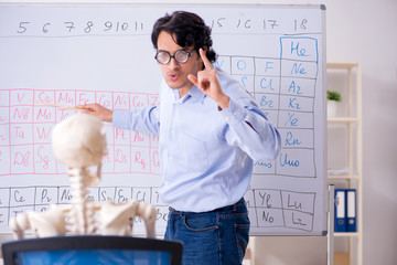 Young male chemist teacher and student skeleton 