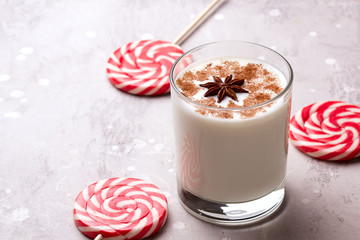 Glass of eggnog and candy cane.