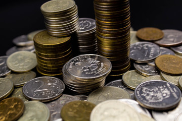 Coins stack on black background in concept wall and strong money.