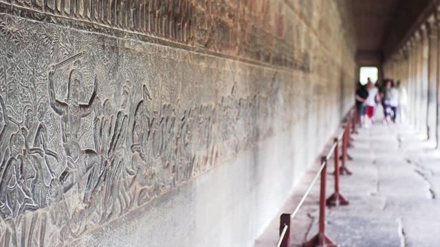Stone carvings in gallery showing warriors in Angkor Wat temple, built by khmer civilization in 12th century and recognized as an important cultural site by UNESCO in 1992. Cambodia