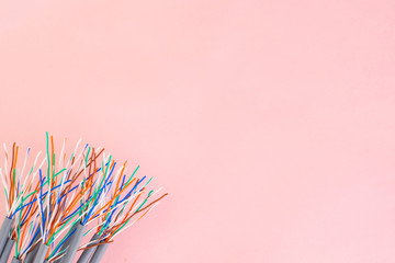 bundle of multicolored wires on a pink surface background