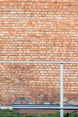 old brick wall behind a metal fence