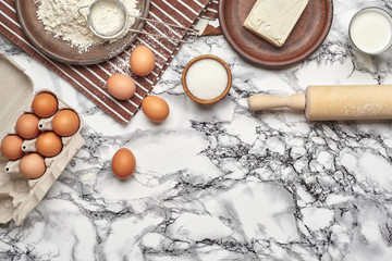 Close-up shot. Top view of a baking ingredients and kitchenware on the marble table background.