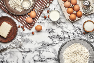 Close-up shot. Top view of a baking ingredients and kitchenware on the marble table background.