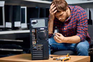 awesome guy thinking about PC repairing at workplace. close up photo, copy space , difficulties in working ,
