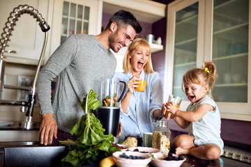 Cheerful girl with parents in kitchen