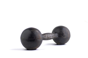fitness and bodybuilding: black metal dumbbell isolated on white background, short focus