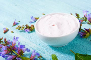 sage herbal plant parts and beauty product samples on turquoise wood table background