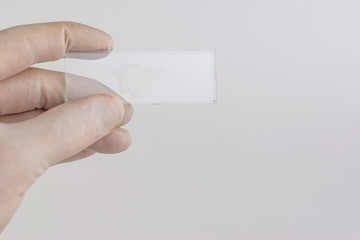 study of synthetic drugs: laboratory technician holds a sample of a new drug, light background, short focus