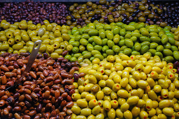 Colorful bowls of marinated olives at a food market