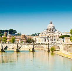 Fototapeta premium St. Peter's Basilica (Basilica Papale di San Pietro in Vaticano) and Tiber river. Sunny spring day in Rome, Italy
